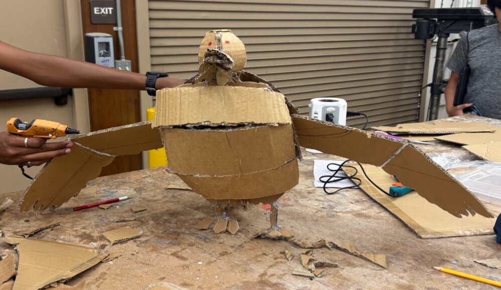 Finished cardboard bird sculpture with spread wings, jointed head, and legs